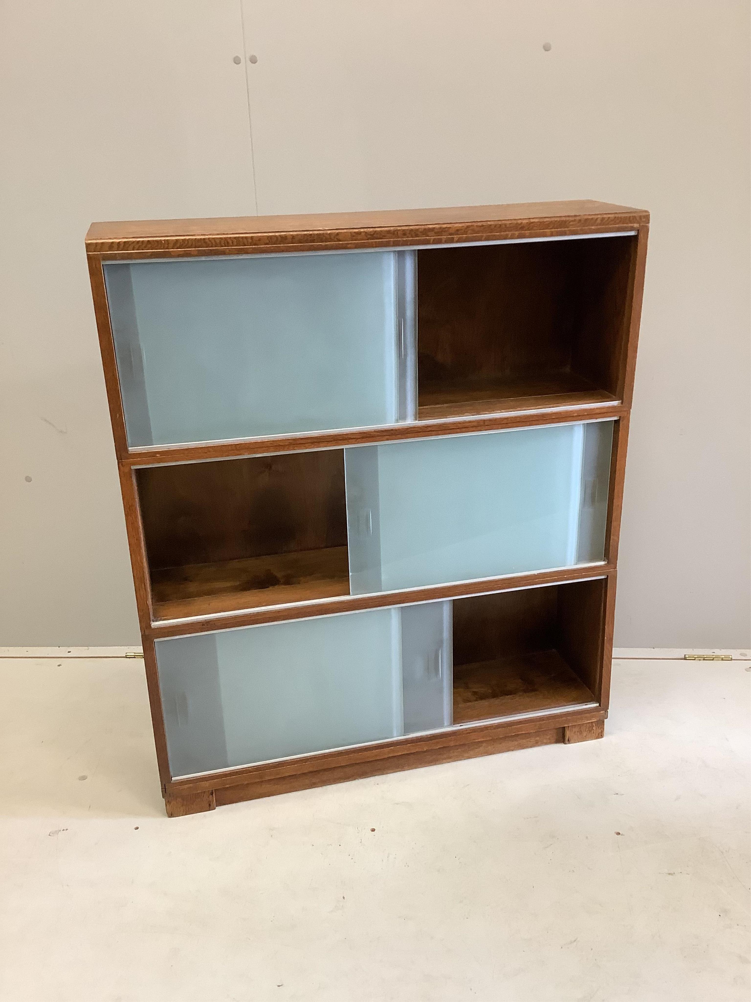 A three section Minty oak bookcase, width 89cm, depth 23cm, height 104cm